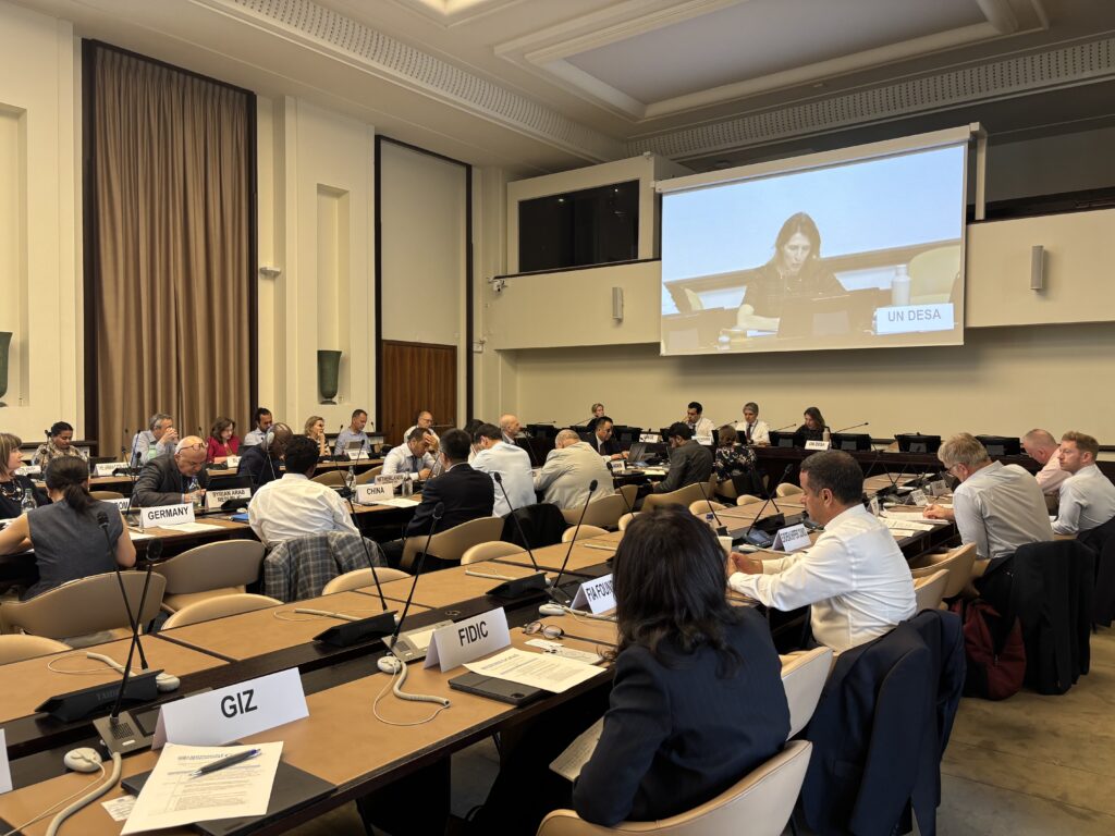 About thirty persons sitting in a conference room with microphones and name tags of their organisations or countries in front of them.
