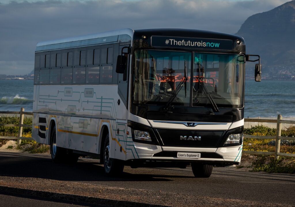 A white electric bus of the brand MAN with a lettering on the sign above the windshield saying #TheFutureIsNow